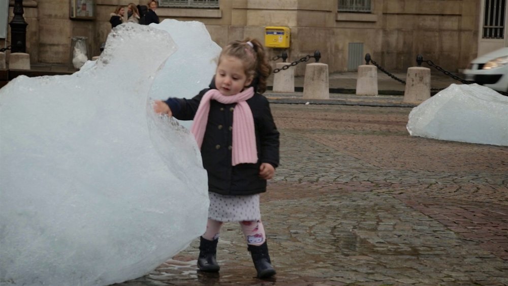 Girl touches melting ice from Arctic glacier at COP21 Paris